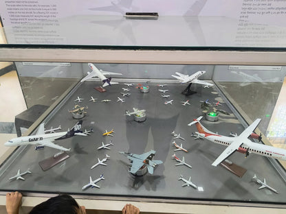 A child looks at a display of model airplanes in a museum.