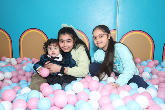 Three children sitting and playing in a pastel-colored ball pit inside Dreamcatchers Indoor Play Area Sector 100 Noida