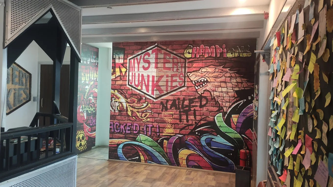 Graffiti mural with a wolf and "Mystery Junkies" text, next to a wall covered in colorful sticky notes.