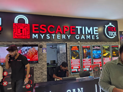 Escape room entrance with neon sign and posters of games. Young men are visible.