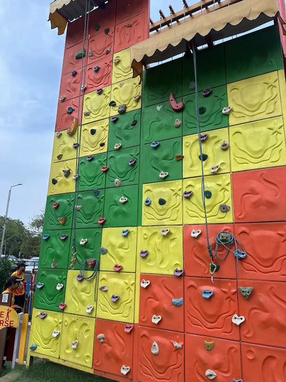 A colorful climbing wall with children and adults participating.