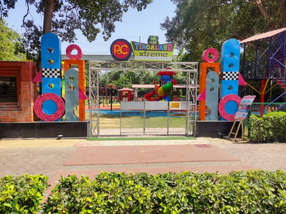 Entrance to a children's park with colorful playground equipment visible.