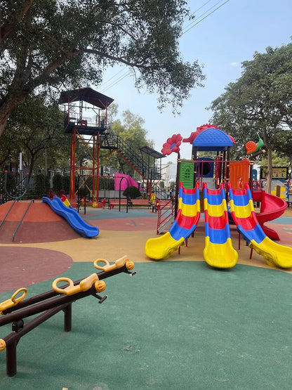 A colorful playground with slides, a seesaw, and a climbing tower for children.