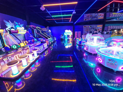 An arcade with neon lights and young adults playing games.