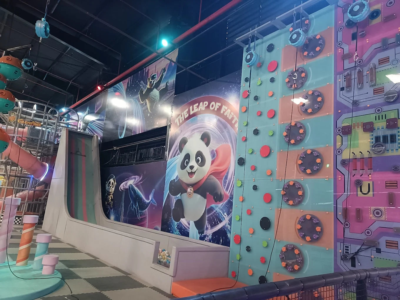 Indoor climbing walls and a slide in a children's play area.