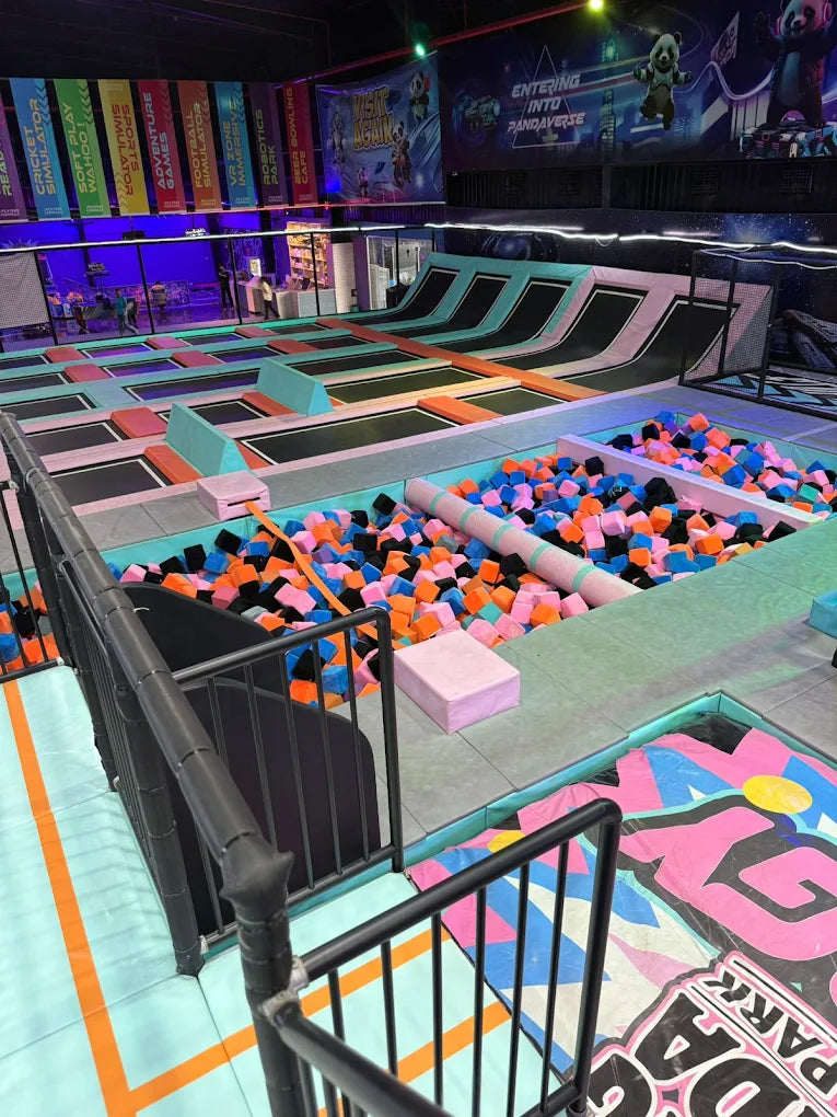 An indoor trampoline park with a foam pit and colorful trampolines.