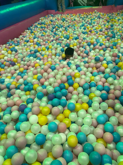 A child plays in a ball pit filled with colorful balls.