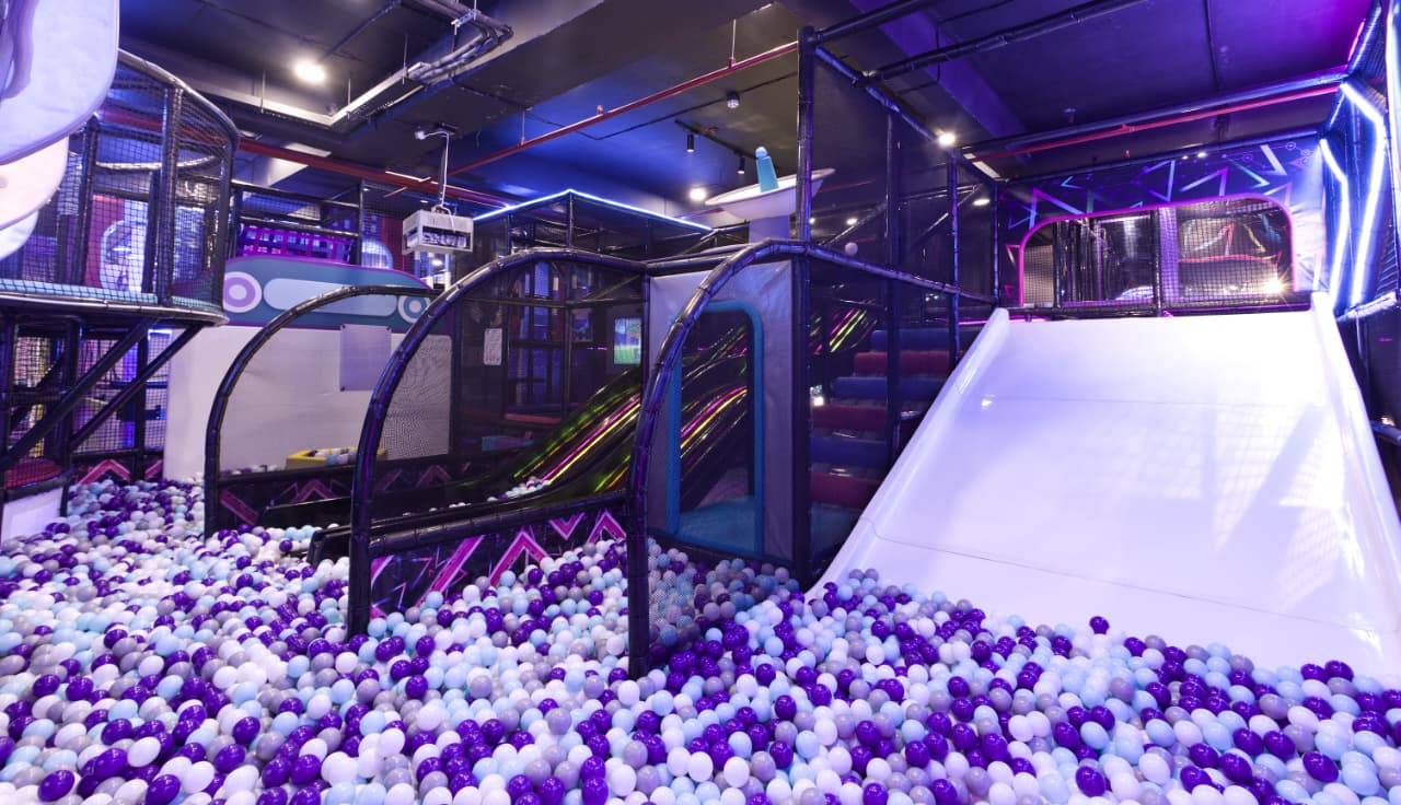Children's play area with ball pit and slides in a indoor playground.