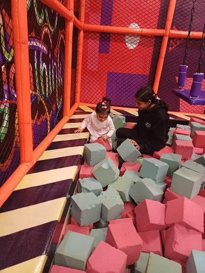 Child and caregiver playing with foam blocks inside enclosed play zone at Fun Orbbit Kids Play Area Gujranwala Town Delhi