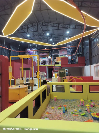 An indoor playground with a ball pit and colorful play structures, viewed from a low angle.