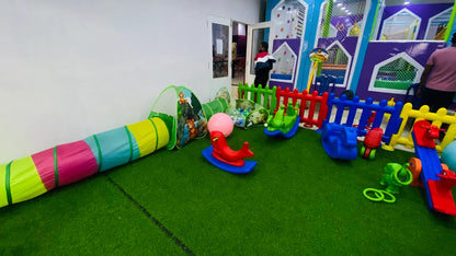 A colorful indoor playground with soft toys and a ball pit for children.