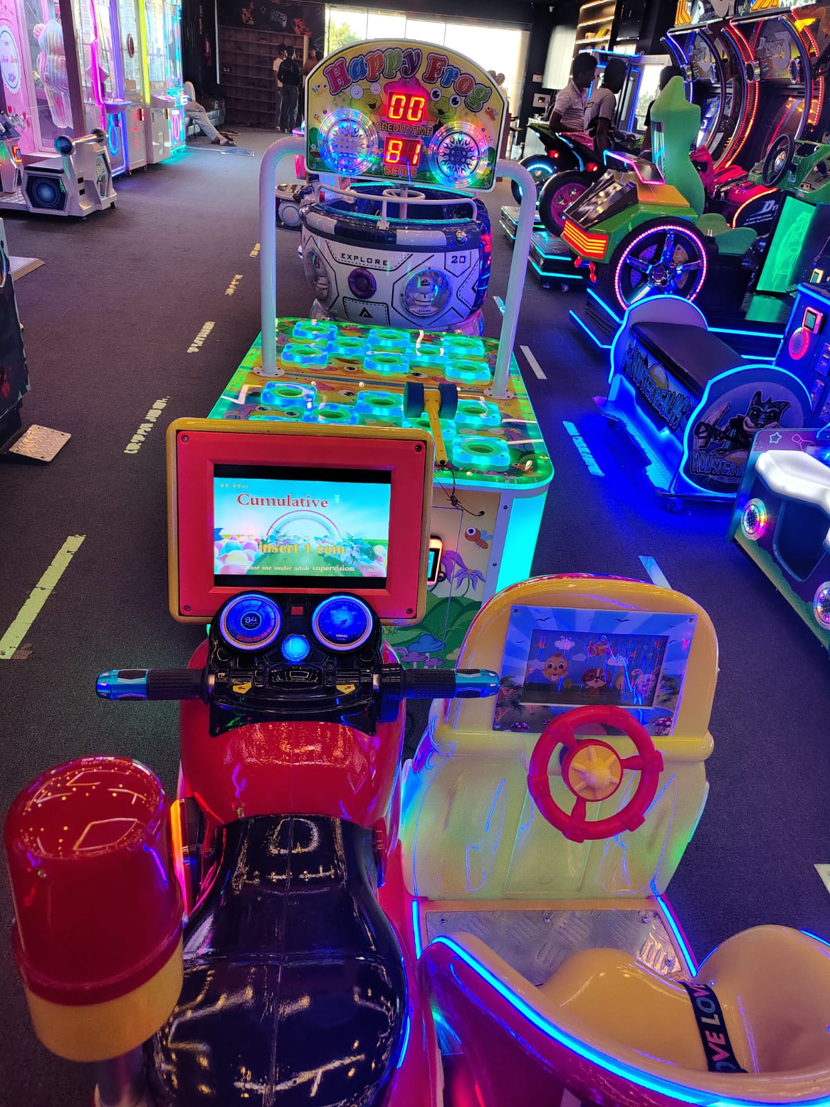Arcade game with a red motorcycle ride and a "Happy Frog" game.