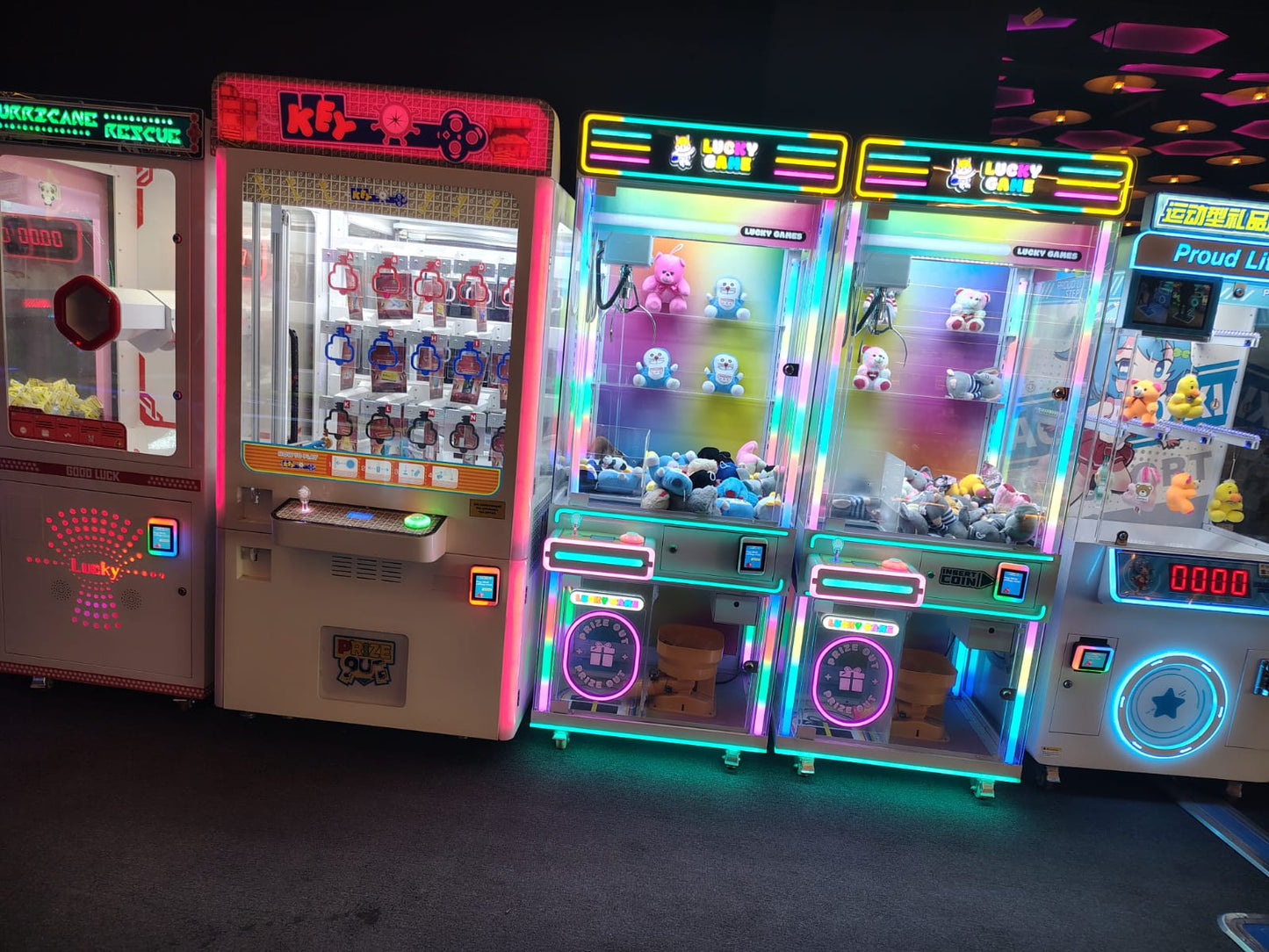A row of colorful arcade claw machines filled with plush toys and prizes.