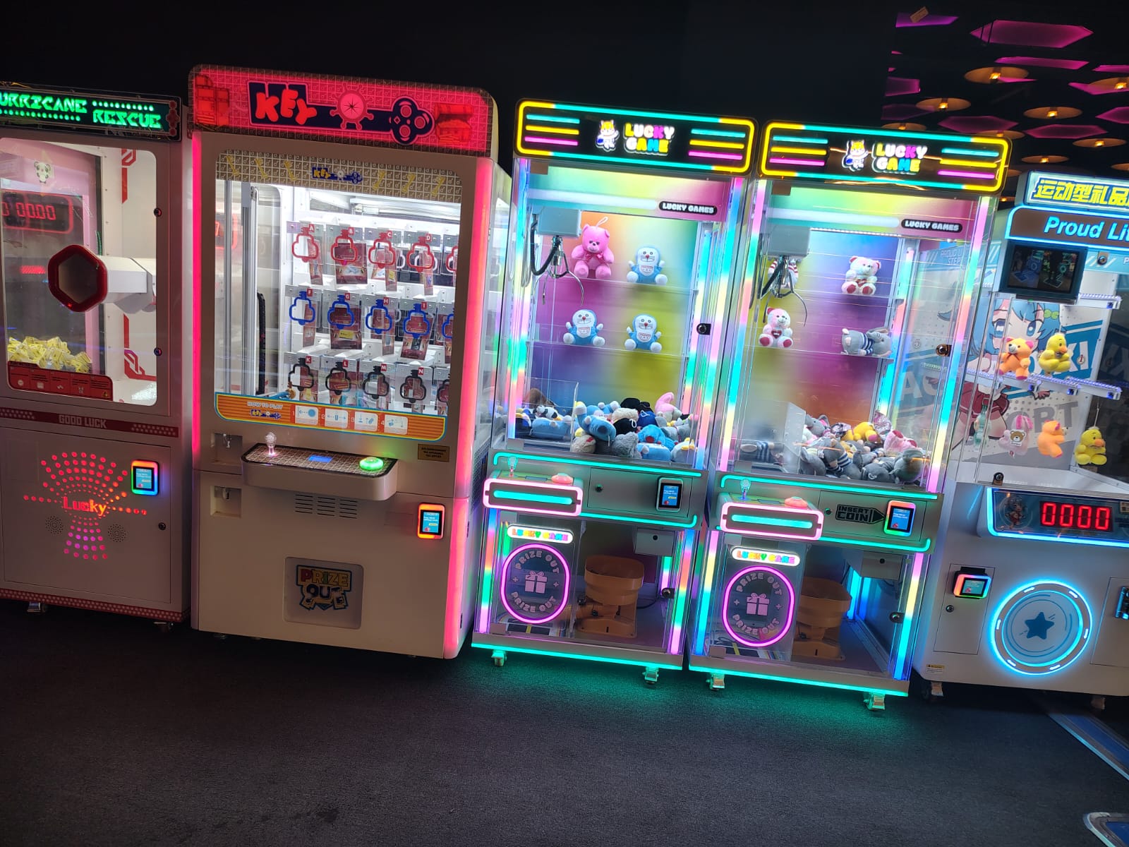 A row of colorful arcade claw machines filled with plush toys and prizes.