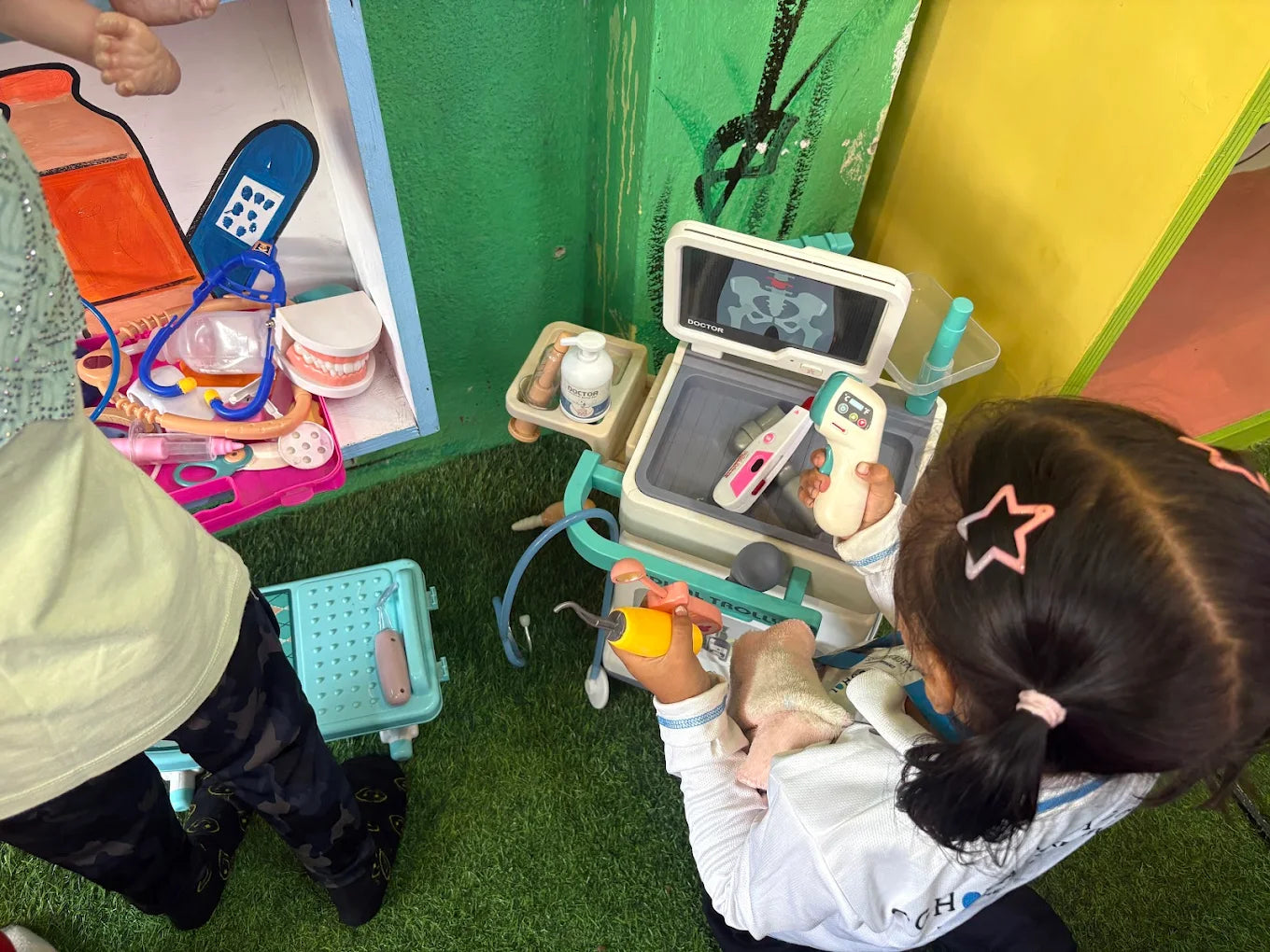 A young child plays with a toy doctor's kit, examining a toy X-ray.