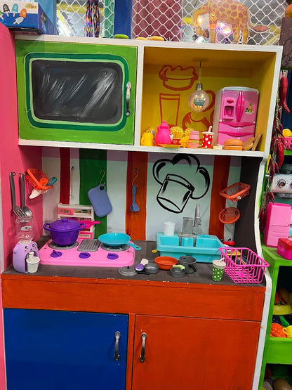 A colorful toy kitchen with miniature appliances and food items, set up for imaginative play.