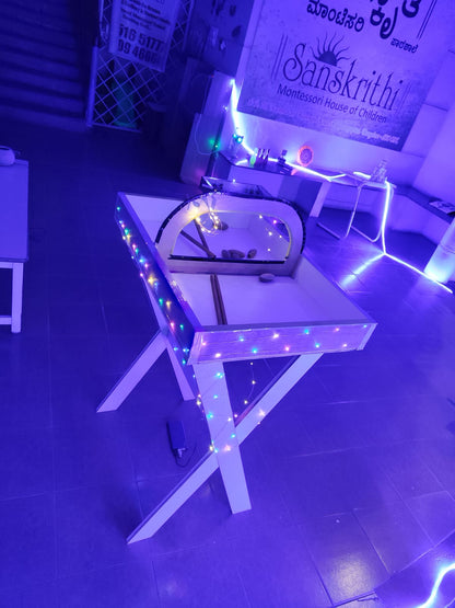 A table with colorful lights and stones is in a room lit by blue lights.