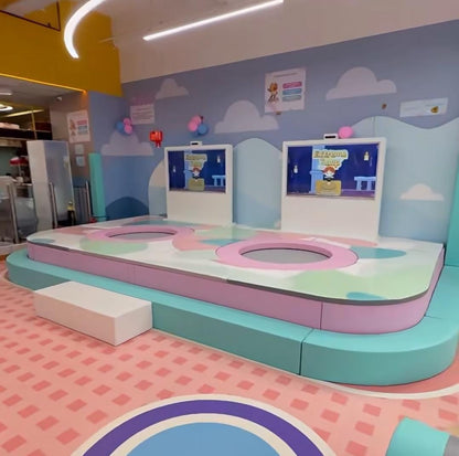A colorful indoor play area with trampolines and interactive screens for children.