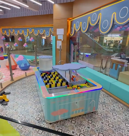 A colorful indoor play area for children with a ball pit and interactive game.