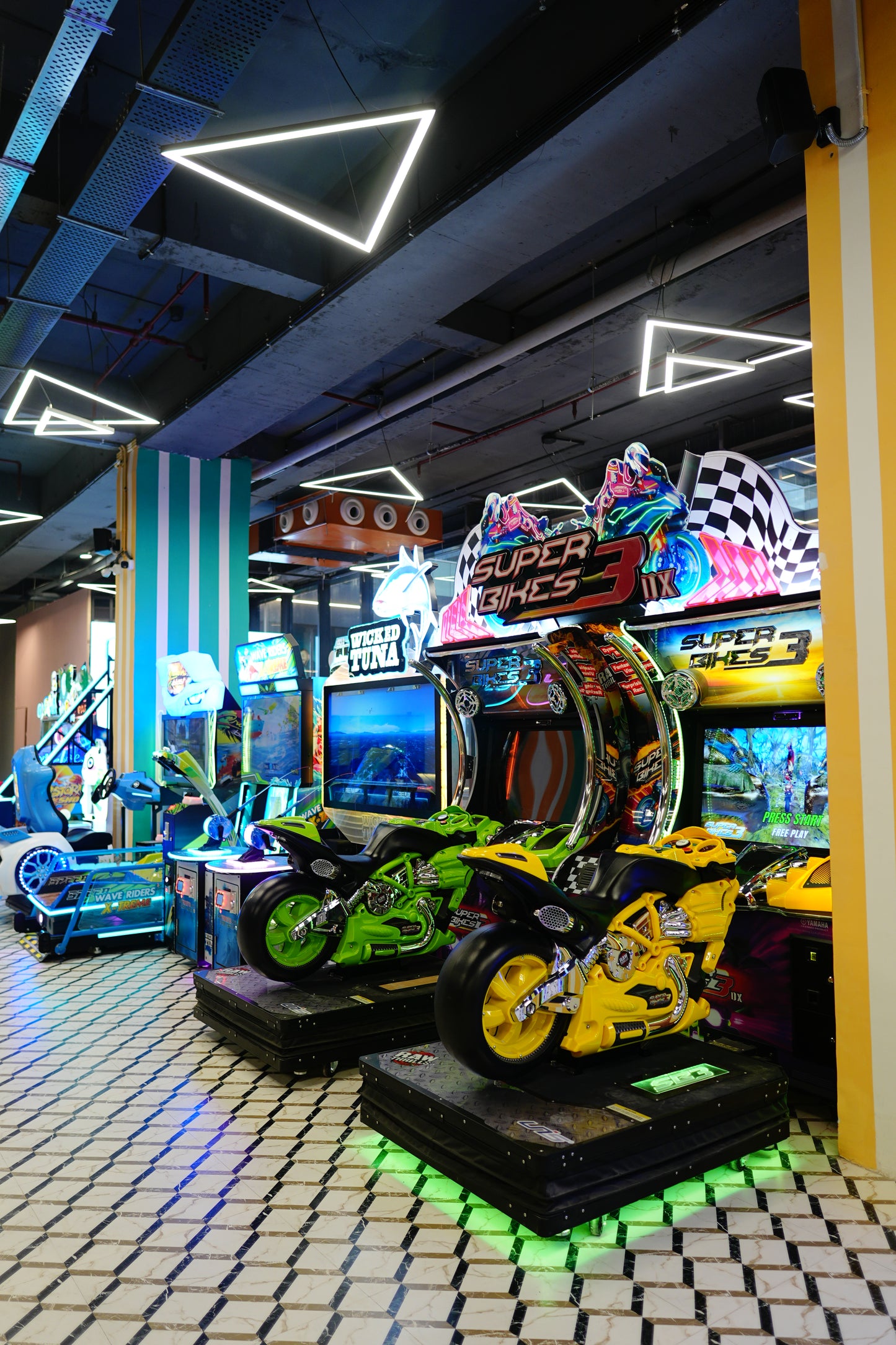 Arcade with racing games, including "Super Bikes 3," featuring colorful motorcycles and neon lights.