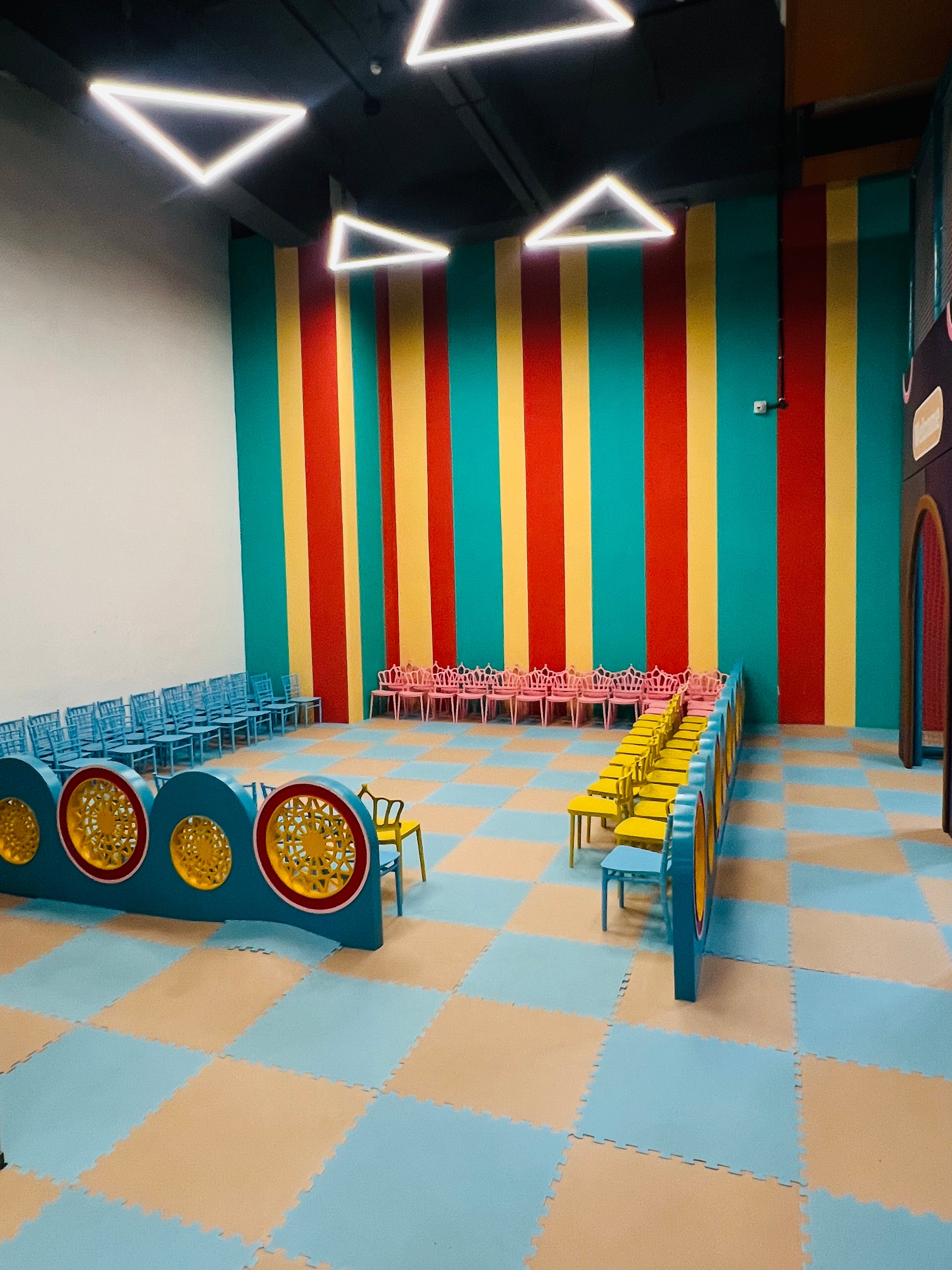 A colorful room with rows of chairs and a checkered floor, likely for children.