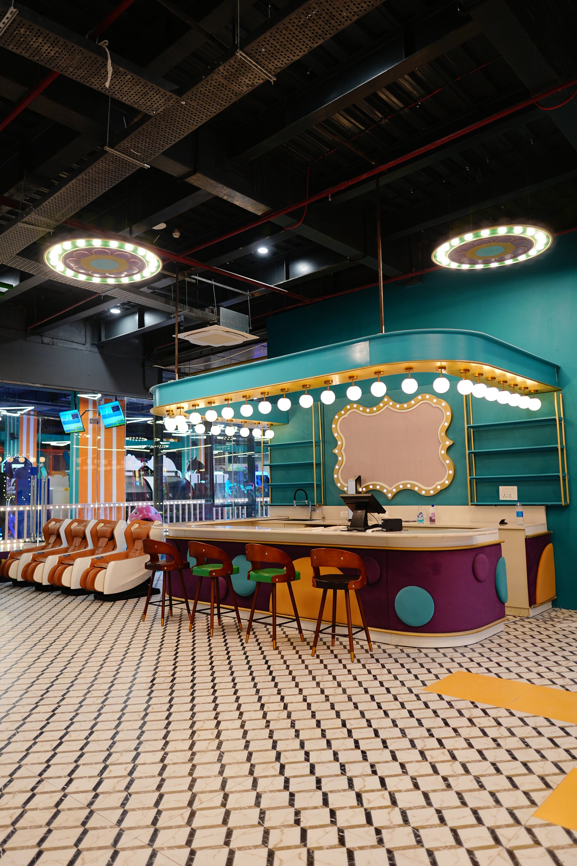 A modern, colorful arcade with massage chairs and a bar.