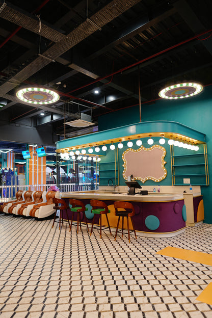A modern, colorful arcade with massage chairs and a bar.