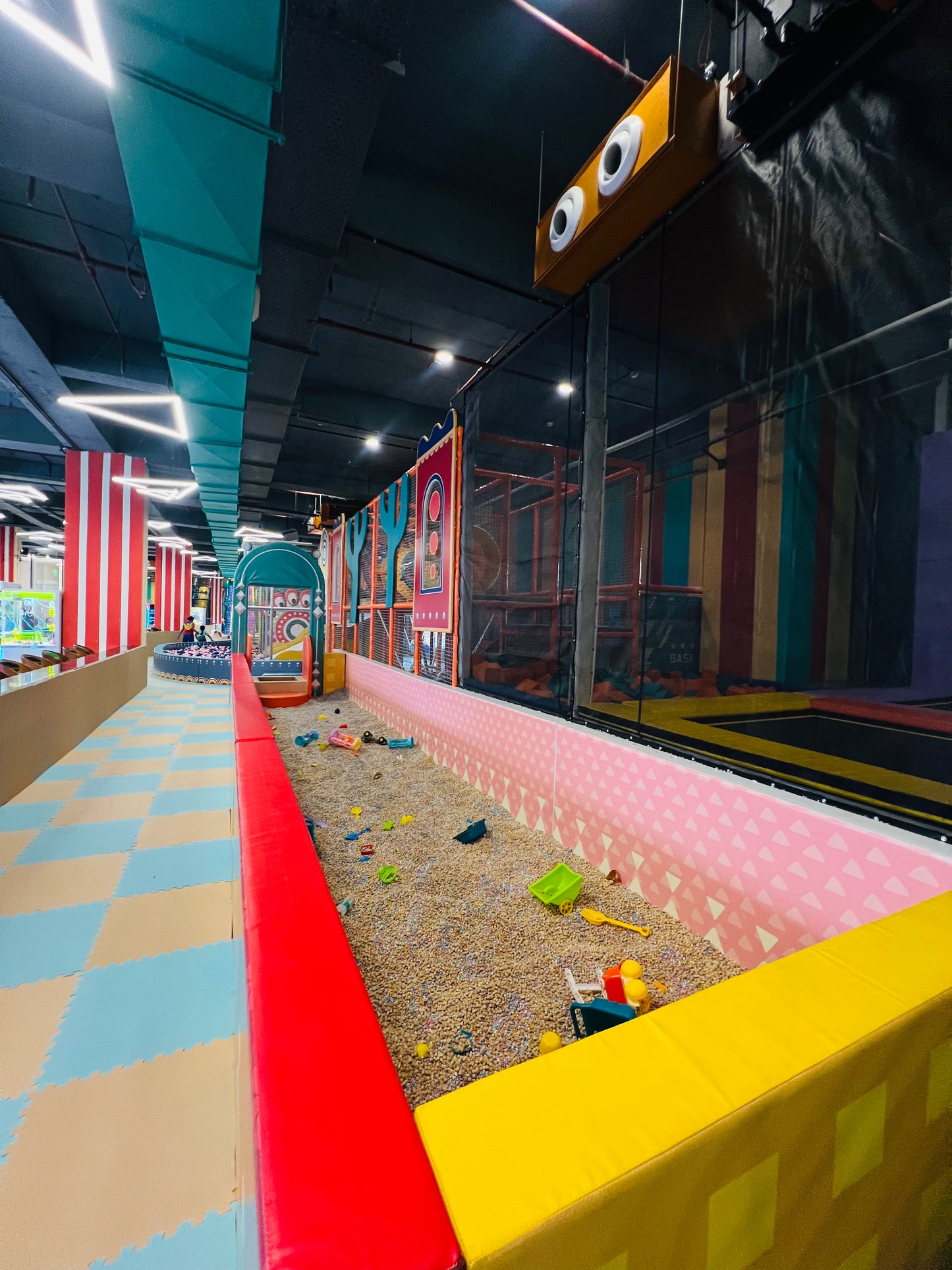 A colorful indoor playground with a ball pit and soft play areas for children.