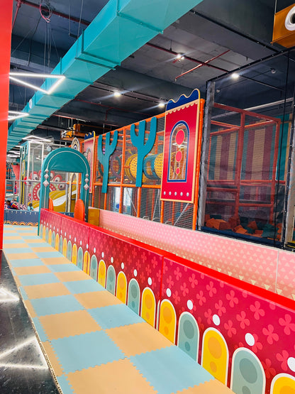 A colorful indoor playground with soft flooring and climbing structures for children.
