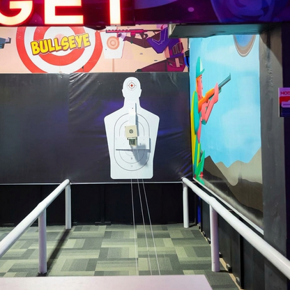 A shooting range with a target dummy and a cartoon character on the wall.