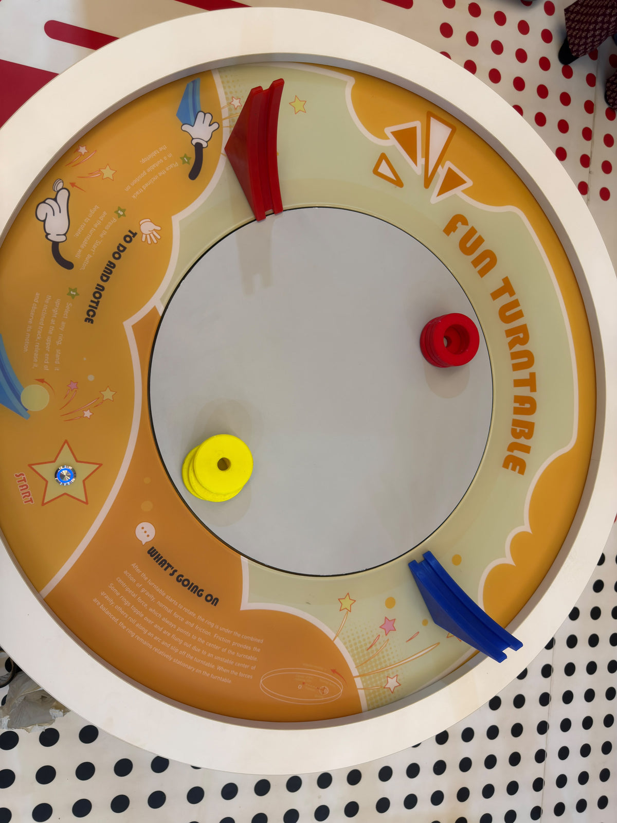 A children's toy turntable with colorful rings and instructions.
