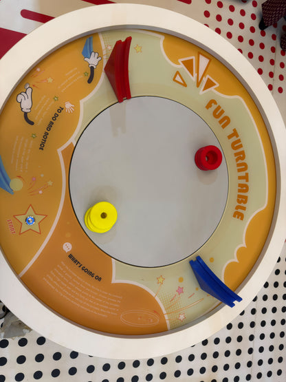 A children's toy turntable with colorful rings and instructions.