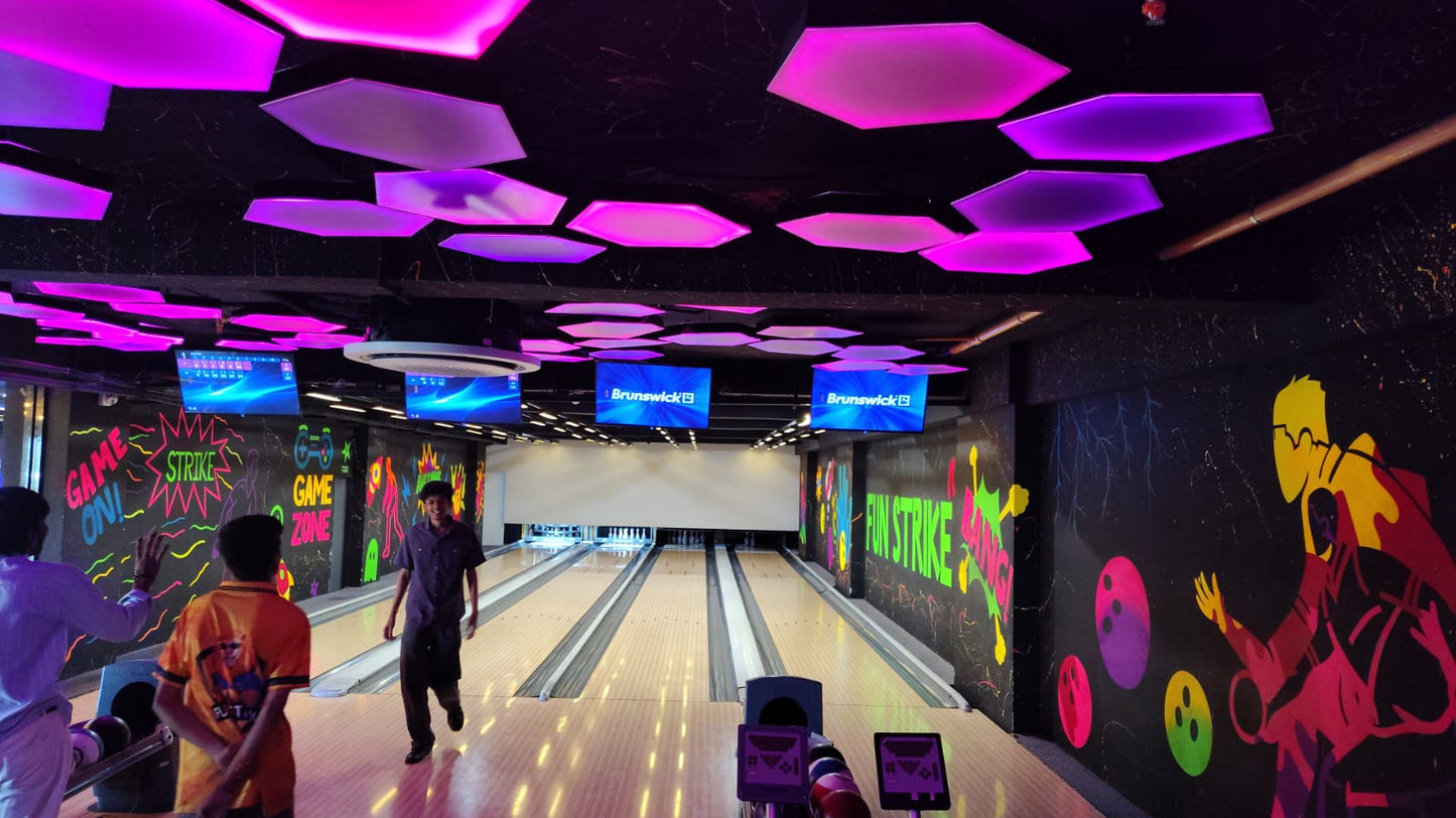 Young people at a brightly lit bowling alley with neon lights and colorful murals.