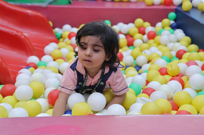 Child playing in a ball pit with colorful balls