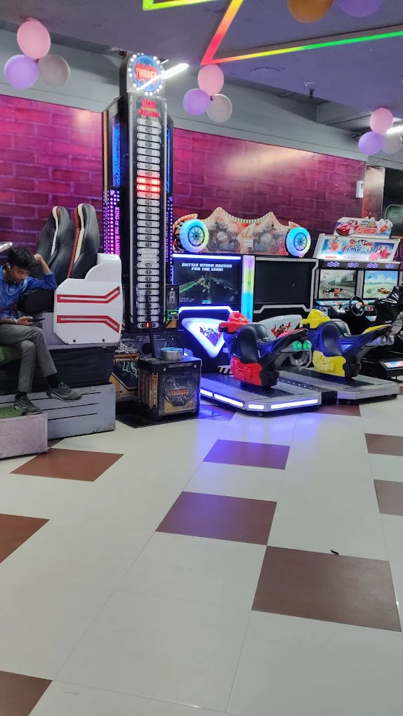 Modern indoor gaming zone with racing simulators, arcade machines, and neon lights creating an exciting entertainment space