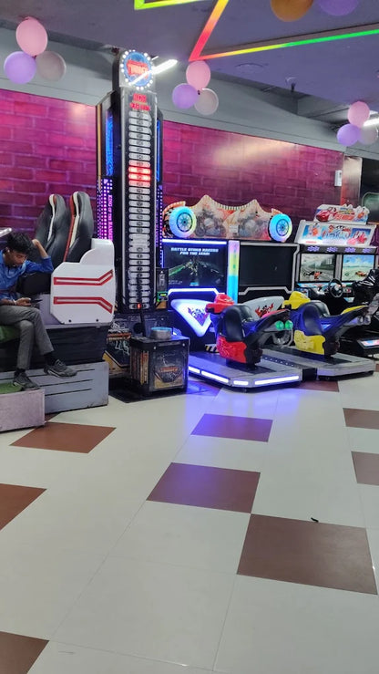 Modern indoor gaming zone with racing simulators, arcade machines, and neon lights creating an exciting entertainment space