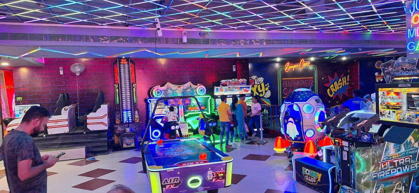 Vibrant indoor entertainment space with various arcade games, air hockey table, and colorful LED ceiling lights