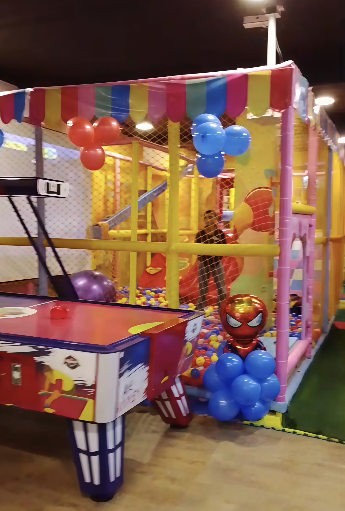 Colorful play area with superhero-themed decorations and balloons.