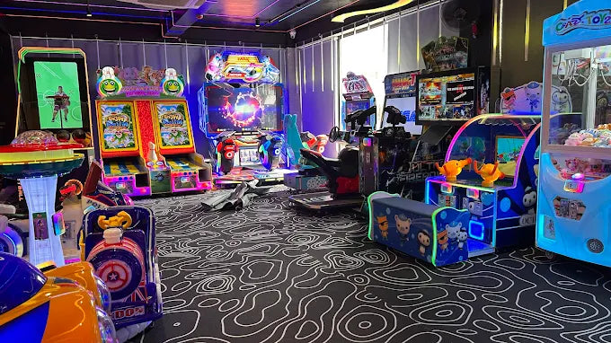 An arcade filled with colorful video games and claw machines, with children playing.