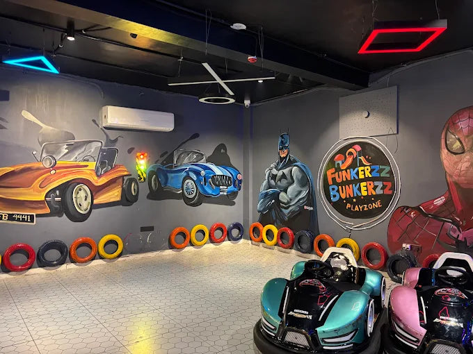 Bumper cars in a play zone with superhero murals and colorful tires.