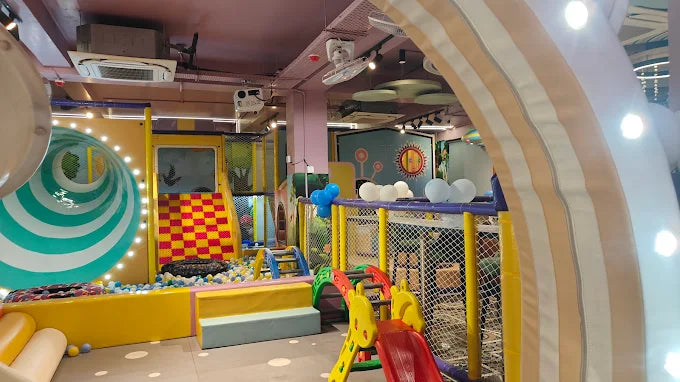 Colorful indoor playground with slides and play structures.