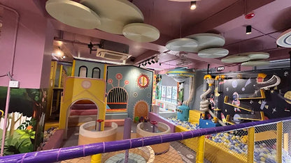 A colorful indoor playground with ball pits and climbing structures for children.