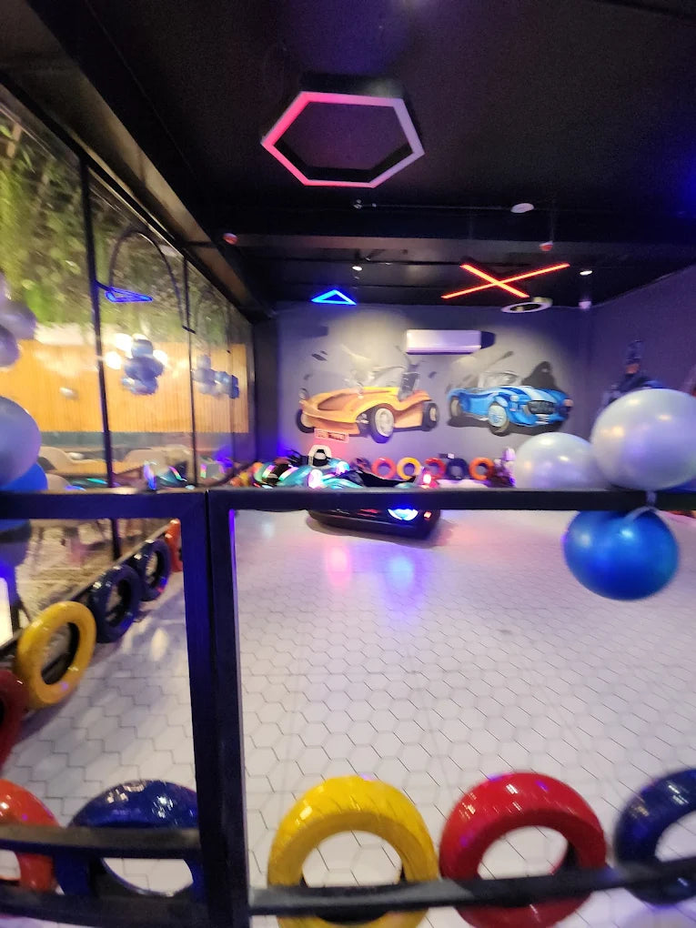 A colorful indoor amusement area with bumper cars and decorative tires, likely for children.