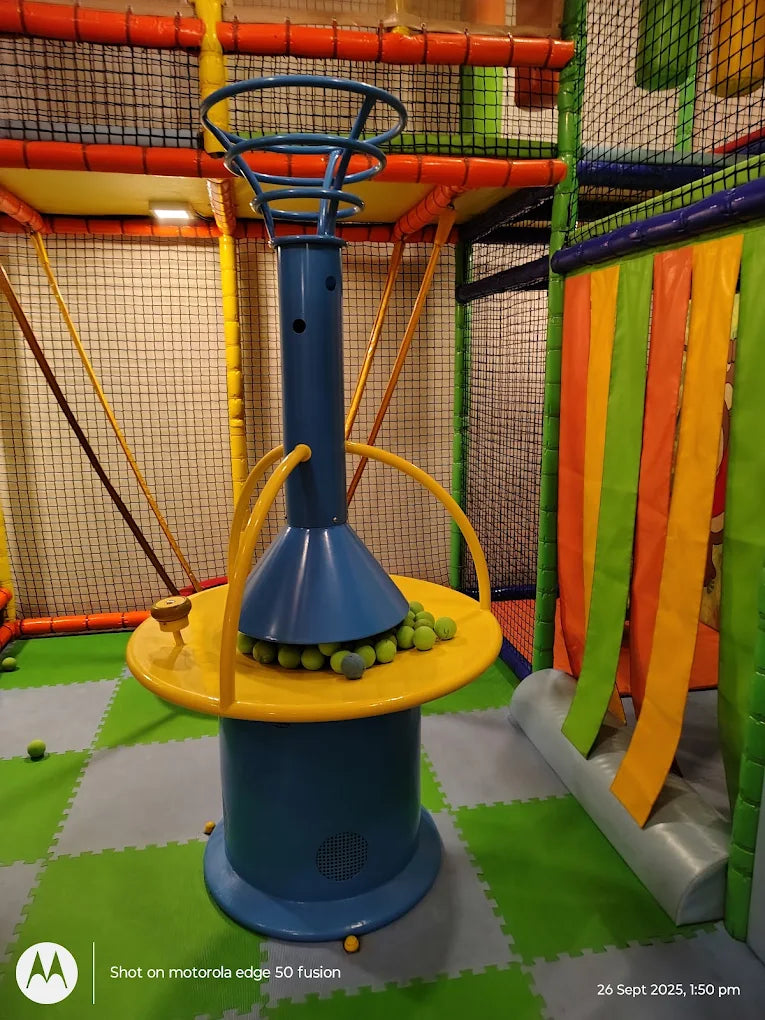 A colorful indoor playground with a ball pit game and soft flooring.