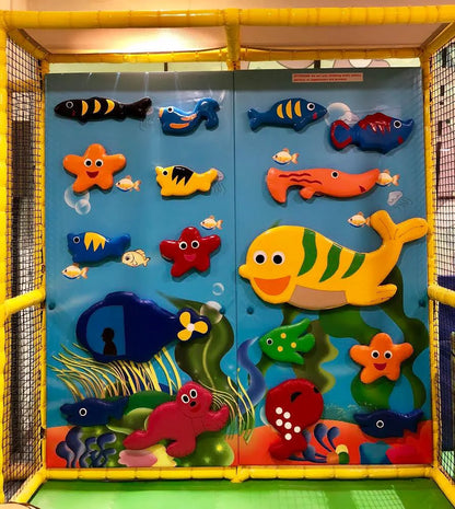A colorful underwater-themed play wall with various fish and sea creatures for children.
