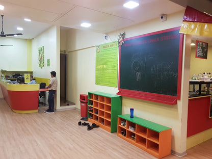A reception area with a chalkboard and shoe cubbies. A young boy stands at a counter.