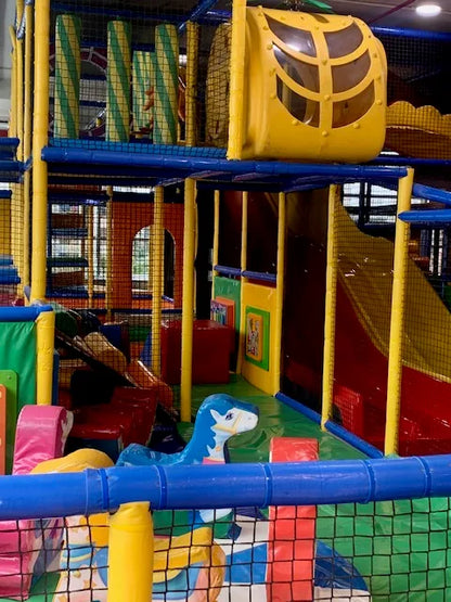 A colorful indoor playground with slides and climbing structures for children.