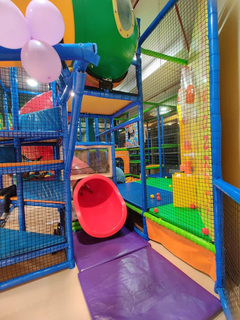 A colorful indoor playground with slides and ball pits, likely for young children.