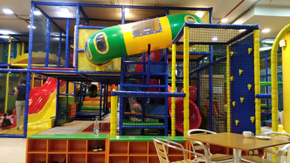 A colorful indoor playground with slides and climbing structures, where children are playing.