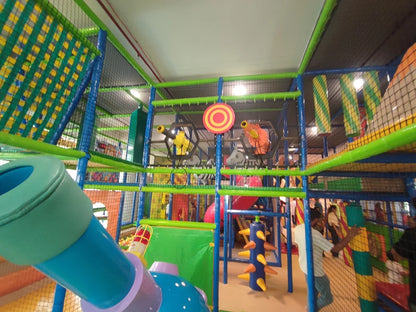 A colorful indoor playground with children playing on slides and climbing structures.